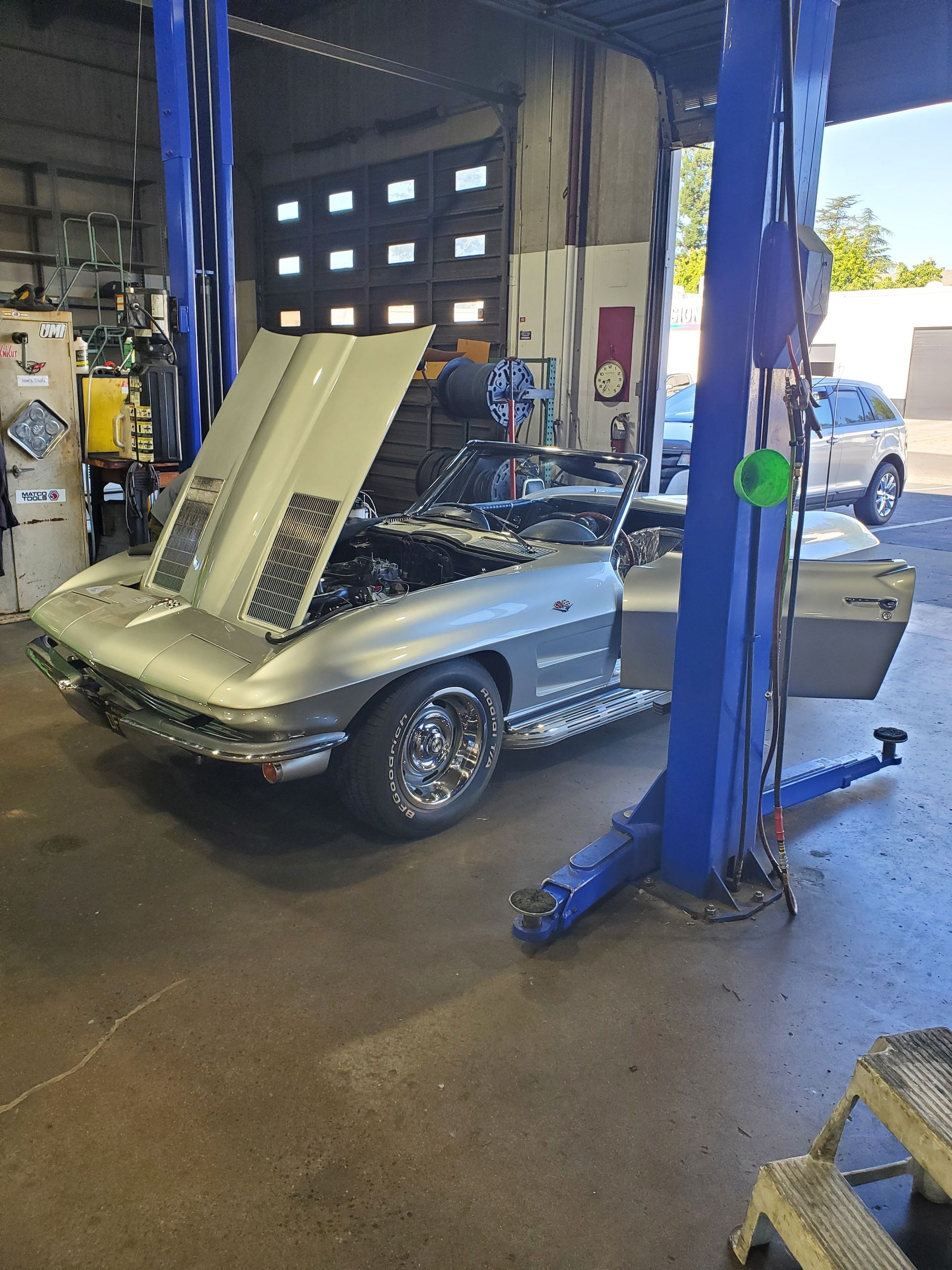 Silver classic convertible car being worked on at an auto repair shop, hood open. | Hal's Auto Care