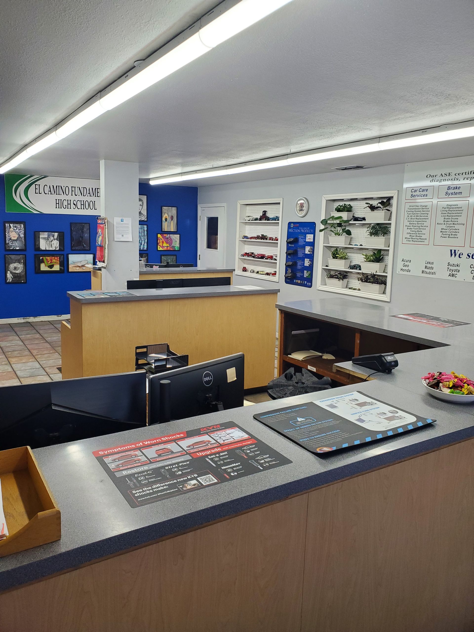 Reception area with a counter, monitors, and product displays. Blue and white walls. | Hal's Auto Care