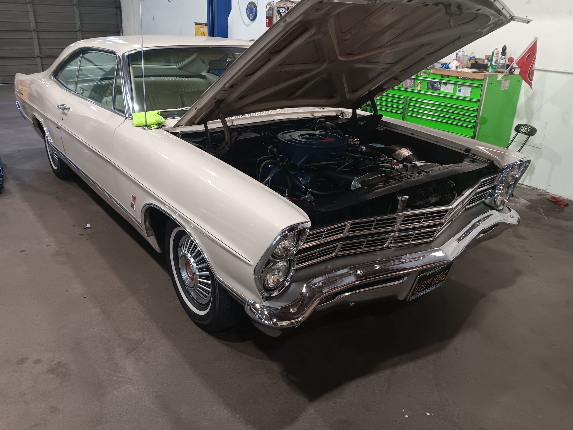 A classic white car with its hood open inside a garage. | Hal's Auto Care