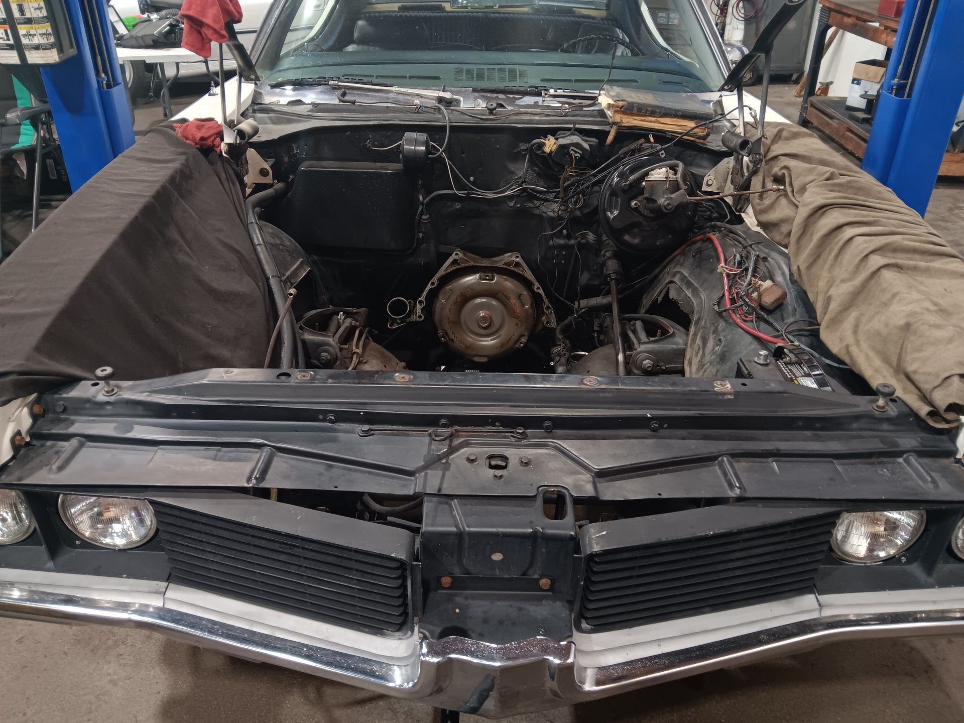 Classic car engine bay open for repairs, black and chrome details. | Hal's Auto Care