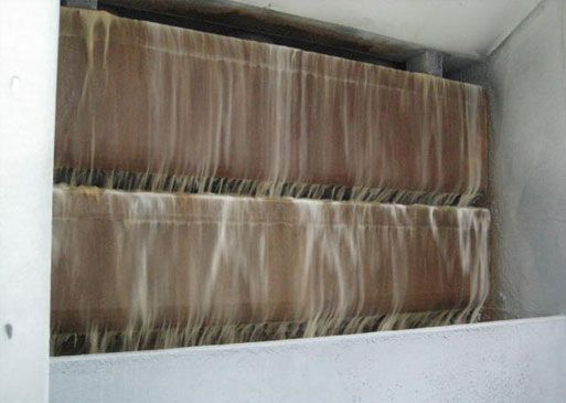 Brown filter blocks with water flowing down in an industrial setting.