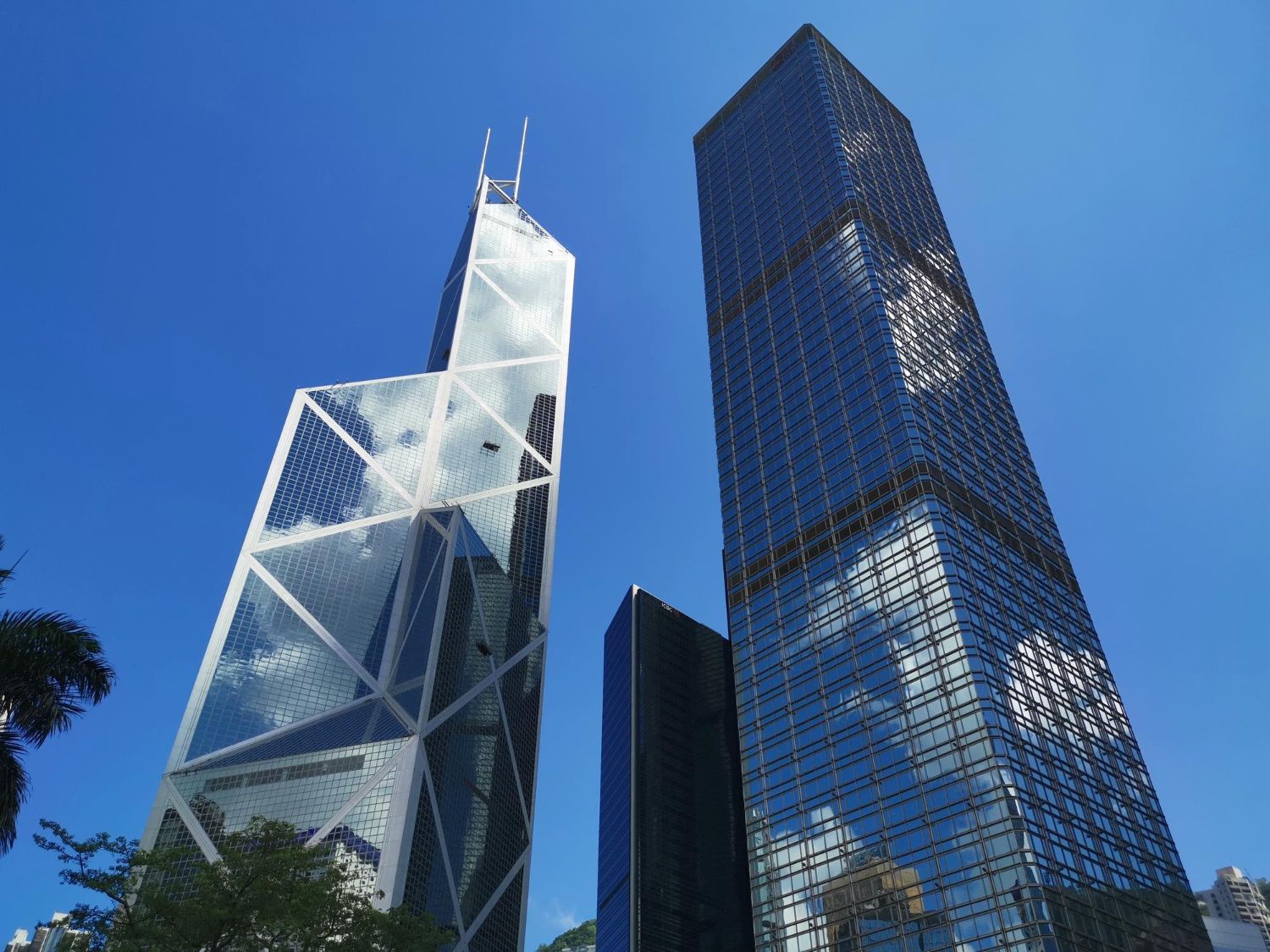 Torre do Banco da China e outros arranha-céus contra um céu azul claro em Hong Kong.