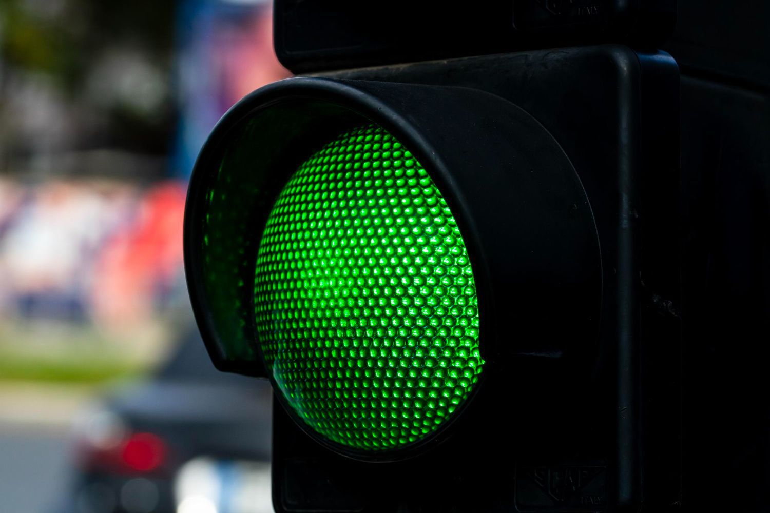 Um grupo diverso em uma reunião, com um homem apresentando em um quadro branco, post-its coloridos, perto de uma janela.