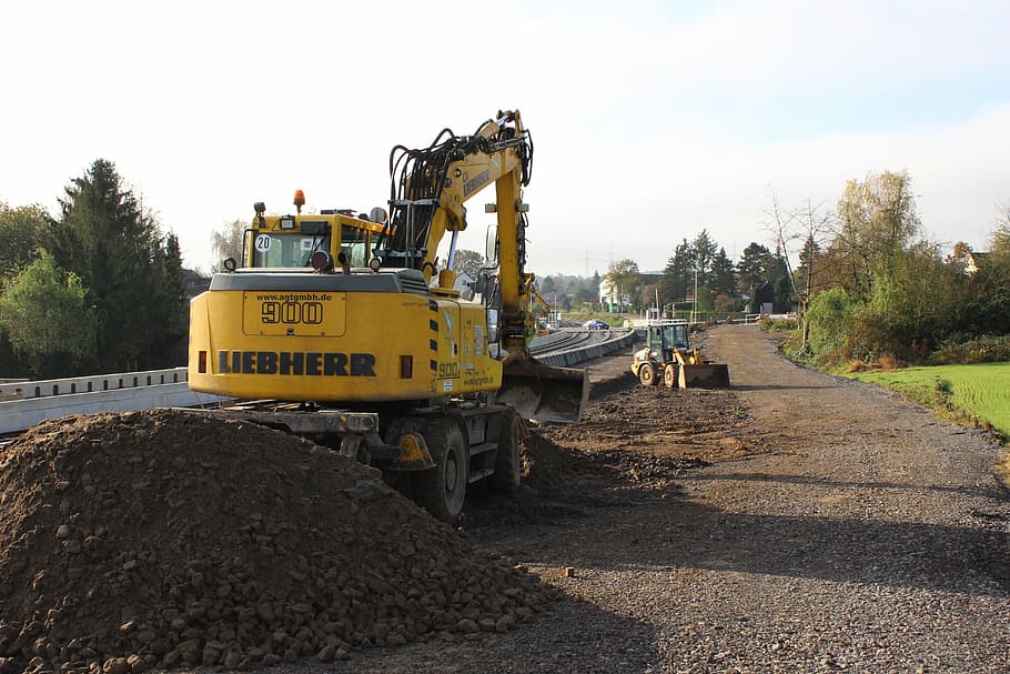 Excavator leveling and compacting subgrade soil.