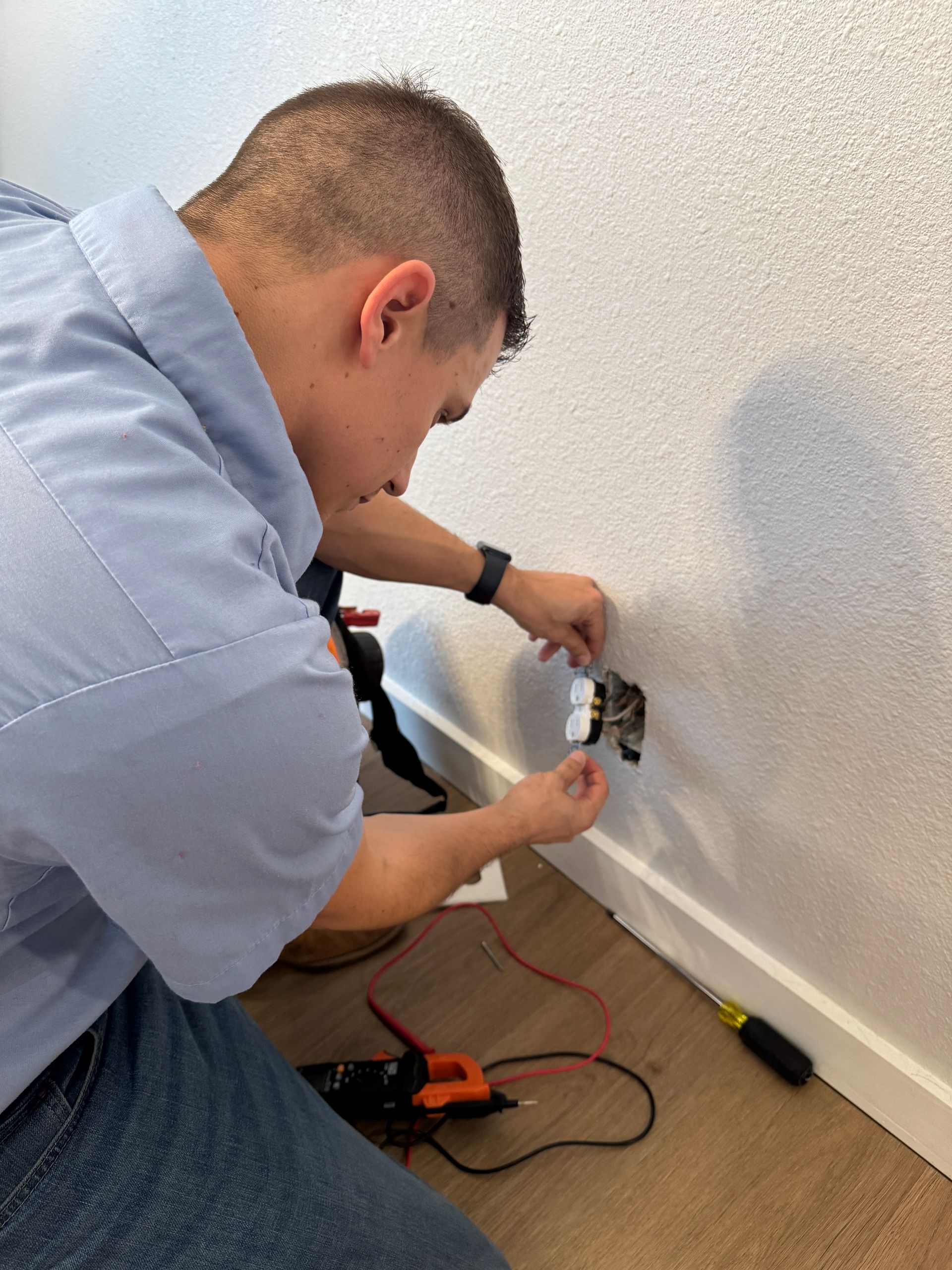A man is installing a light fixture on the ceiling in a kitchen.