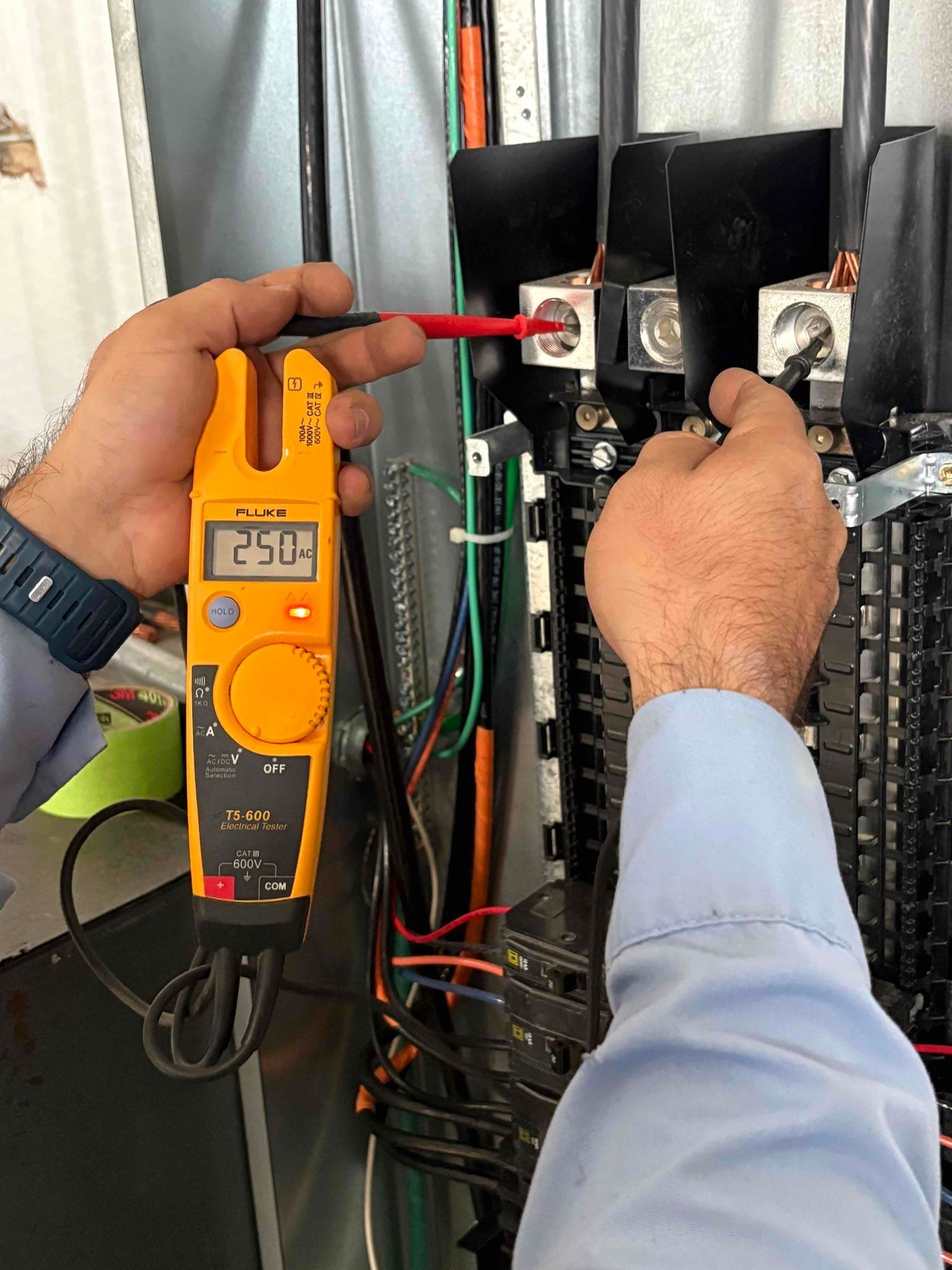 A man is installing a light fixture in a kitchen.