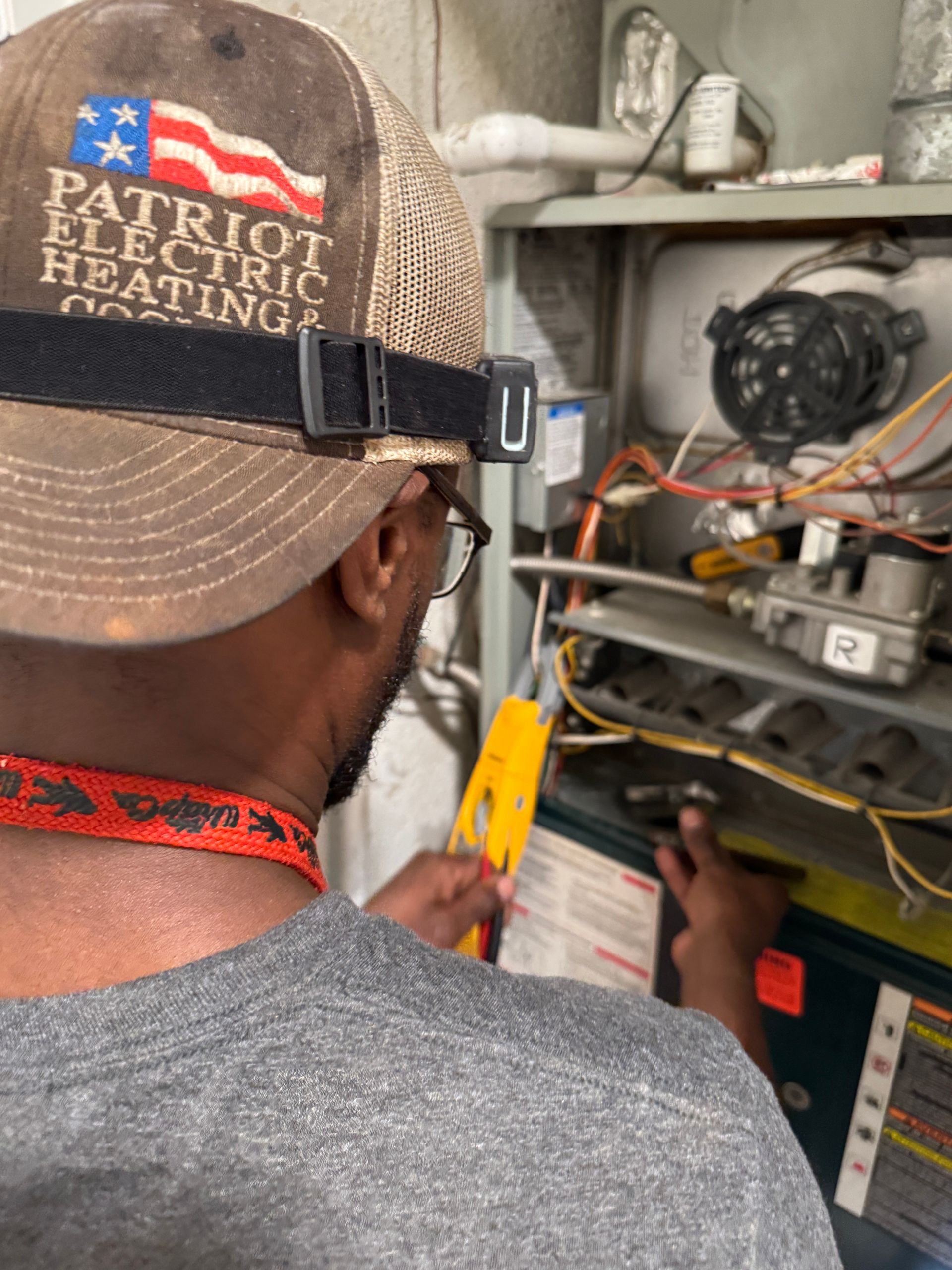 An air conditioner is sitting on the side of a brick building.