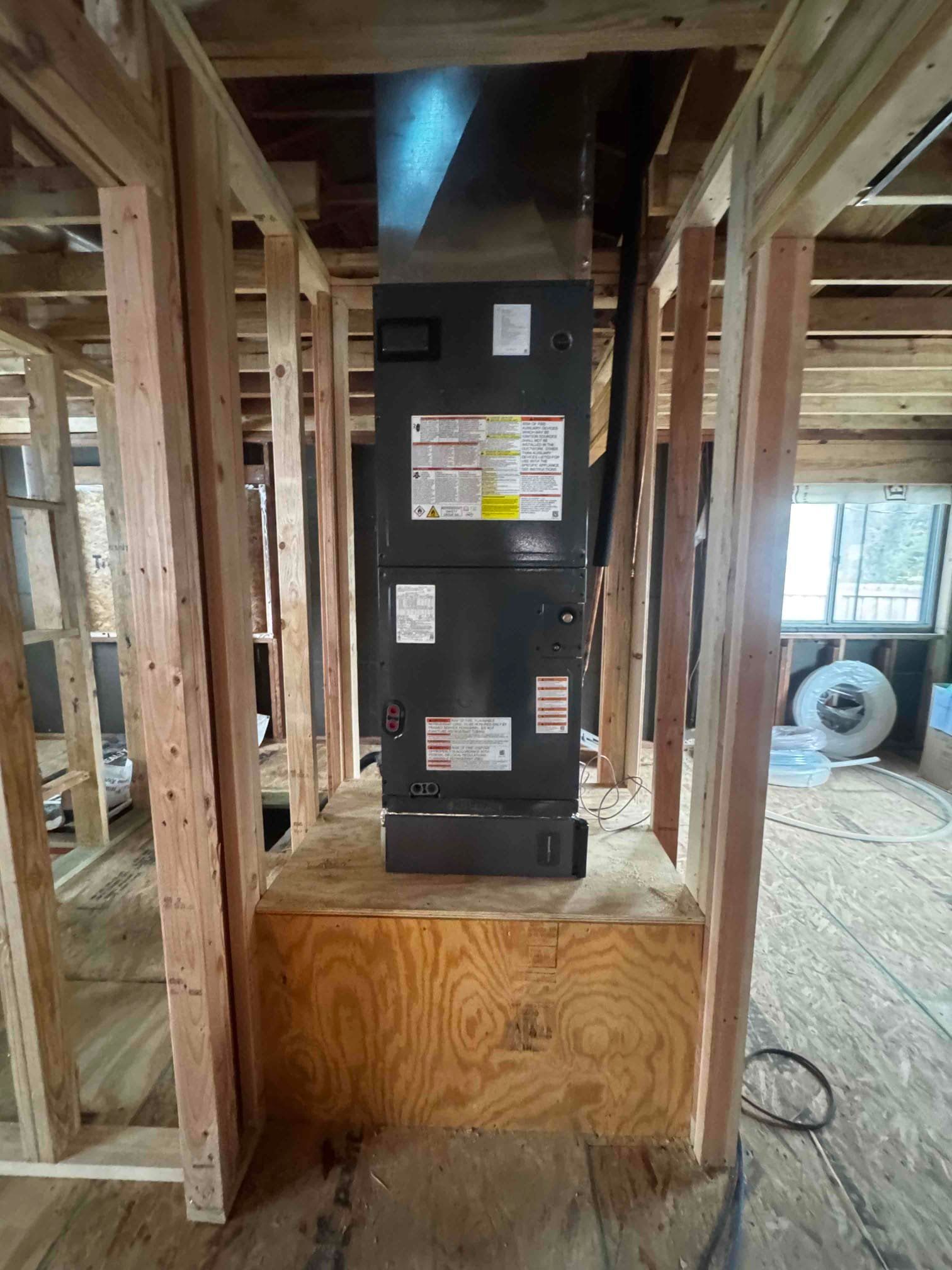 A large water heater is sitting in a room next to a wall.