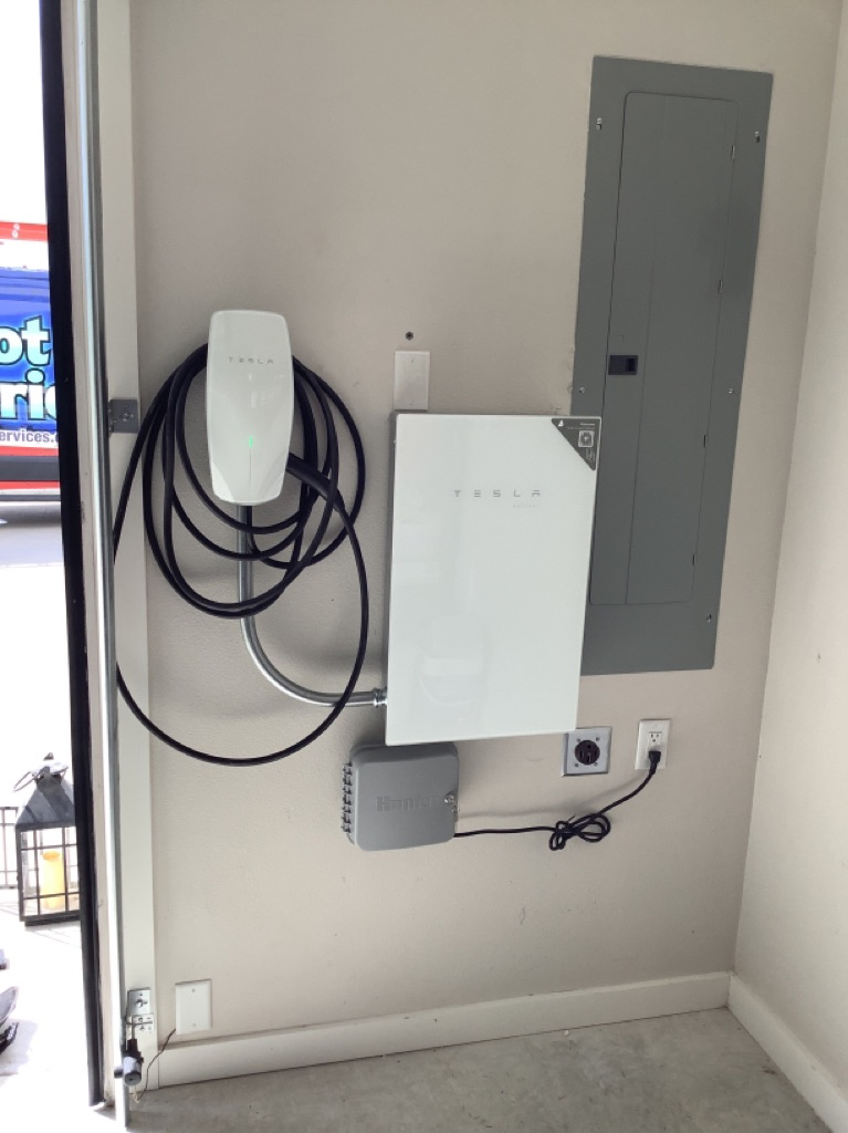 A man is charging his electric car at a charging station.