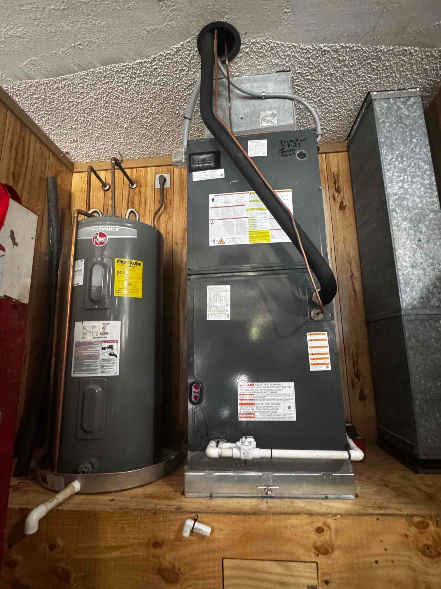 A row of air conditioners are sitting outside of a brick building.