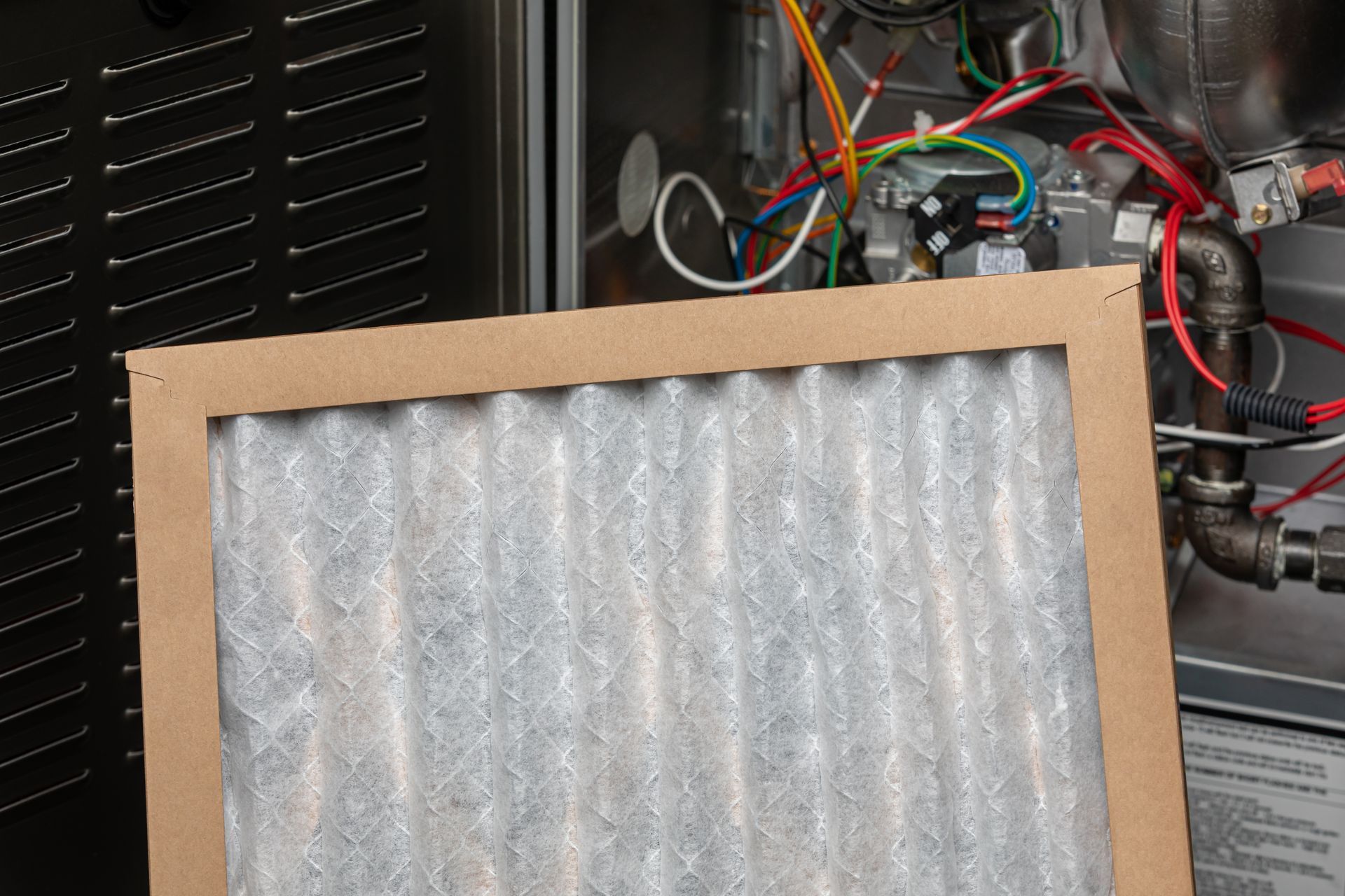 An air filter is sitting in front of an air conditioner.