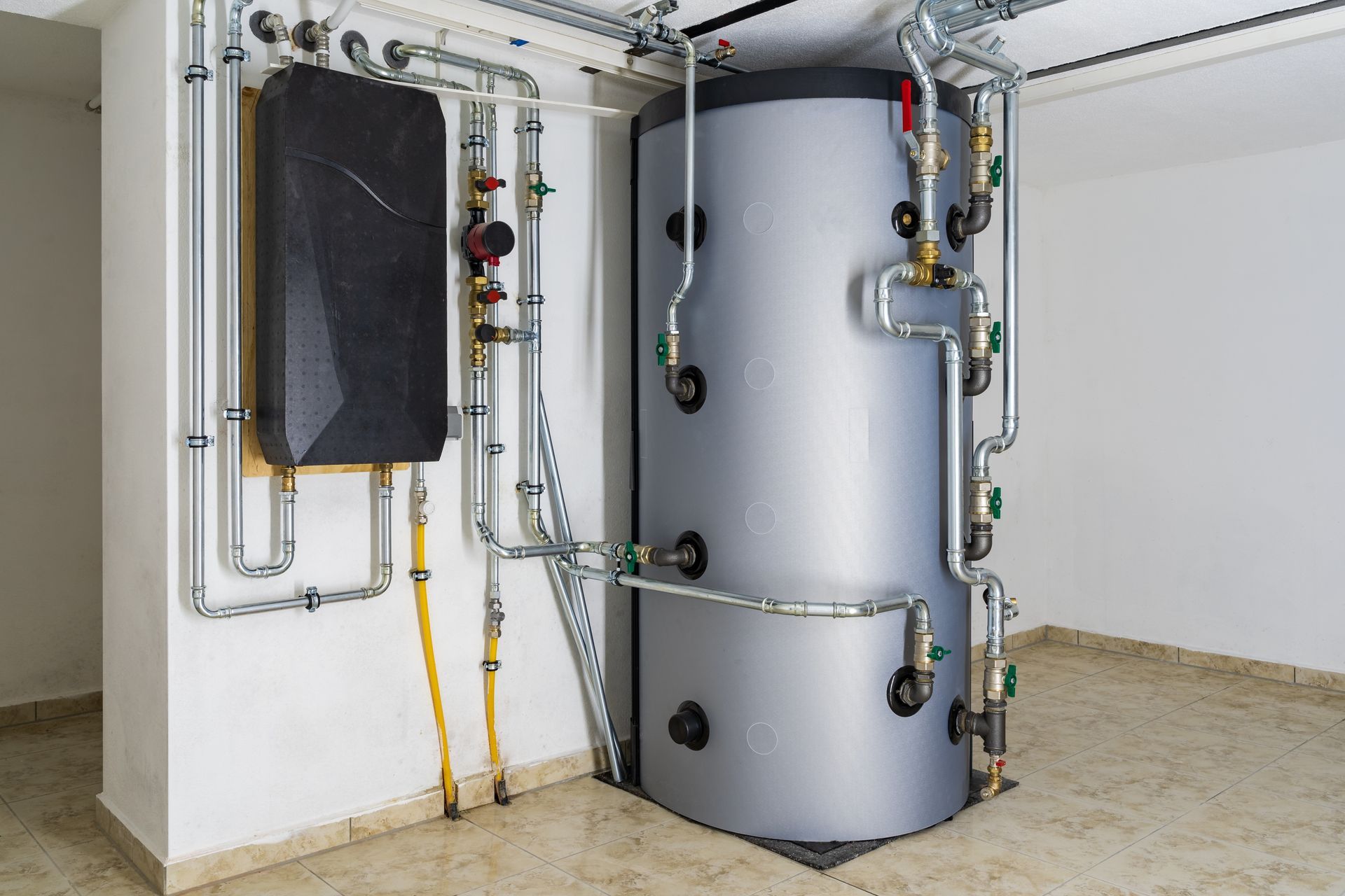 A large water heater is sitting in a room next to a wall.