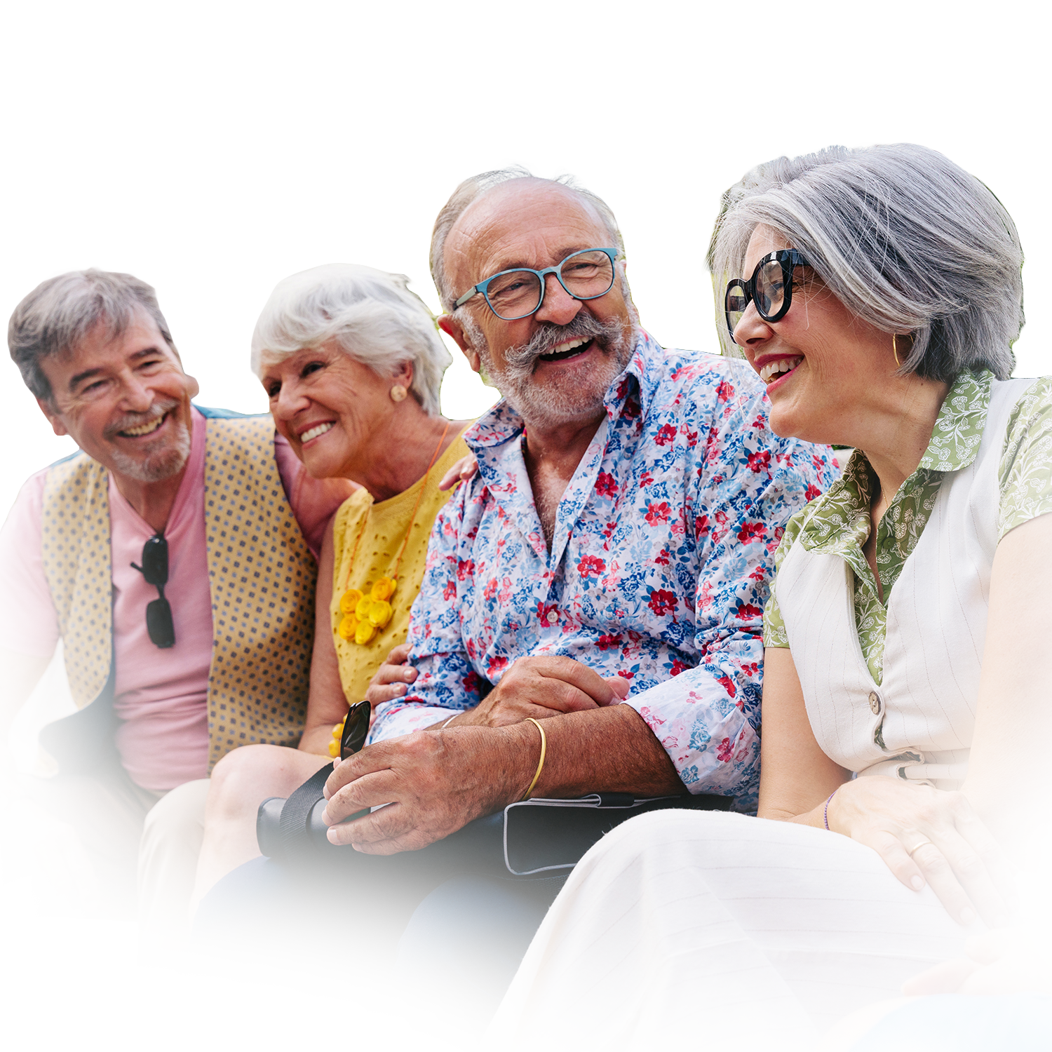 Four people sit together outdoors, laughing and smiling, wearing casual, brightly colored clothing against a white background.