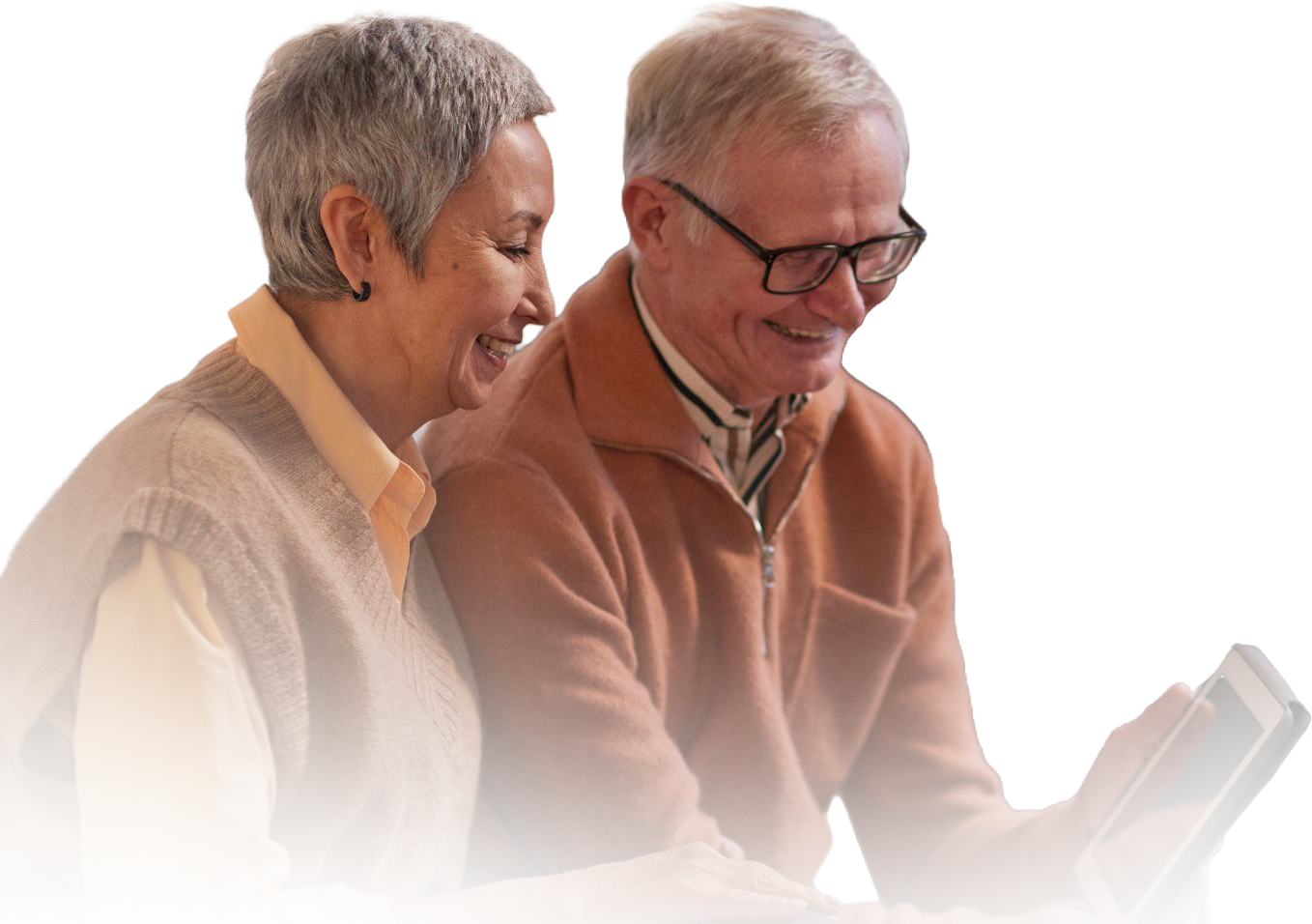 Two people smiling while looking at a tablet together against a white background.