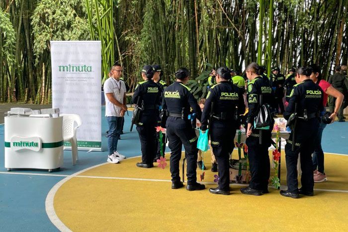 Una mujer está escribiendo en un trozo de papel mientras está sentada en una mesa con otras personas.