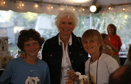 A woman is posing for a picture with two young boys
