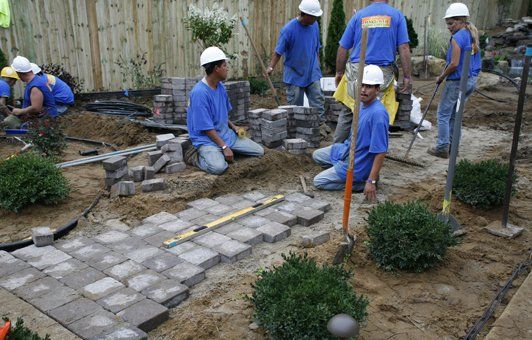 A group of construction workers are working on a garden.