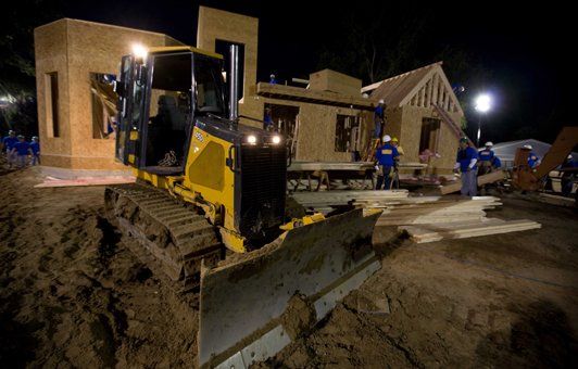 A bulldozer is working on a construction site at night.