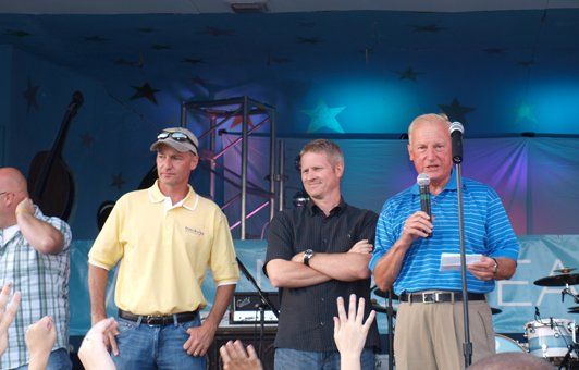 A group of men standing in front of a microphone