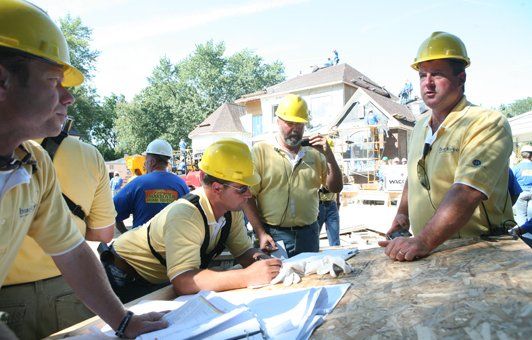 A group of construction workers wearing yellow hard hats