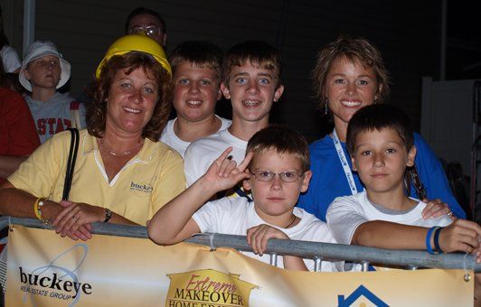 A group of people standing in front of a buckeye banner