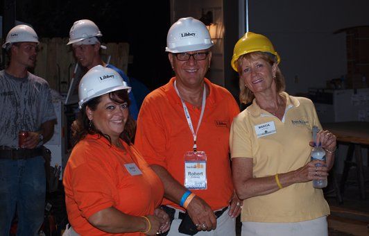 A group of people wearing hard hats are shaking hands