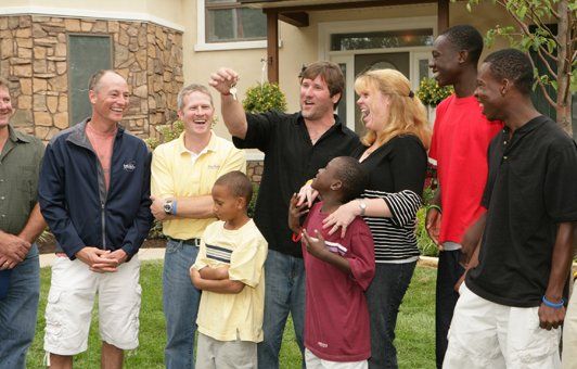 A group of people standing in front of a house