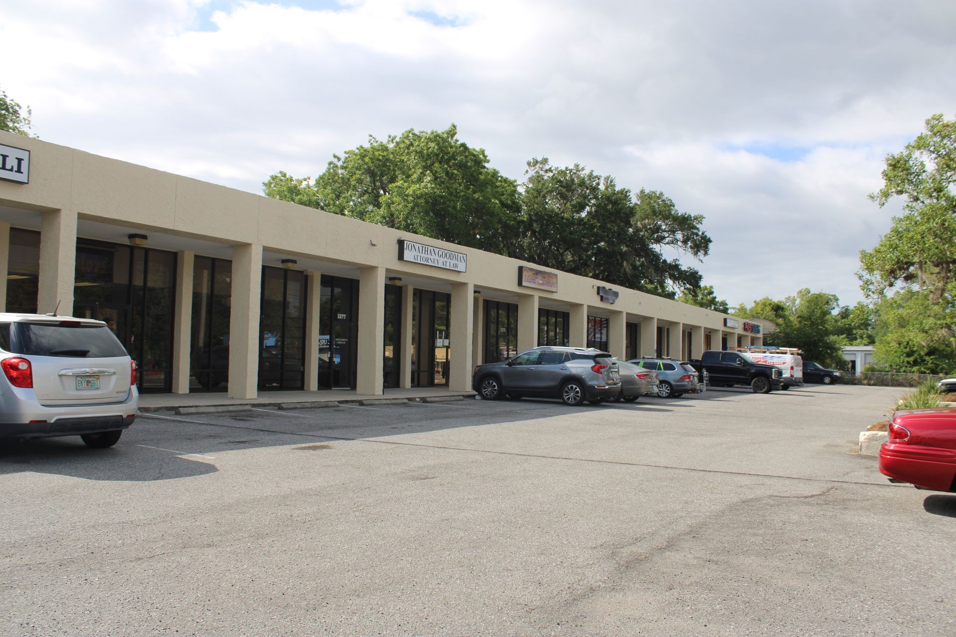 A row of cars are parked in front of a building.