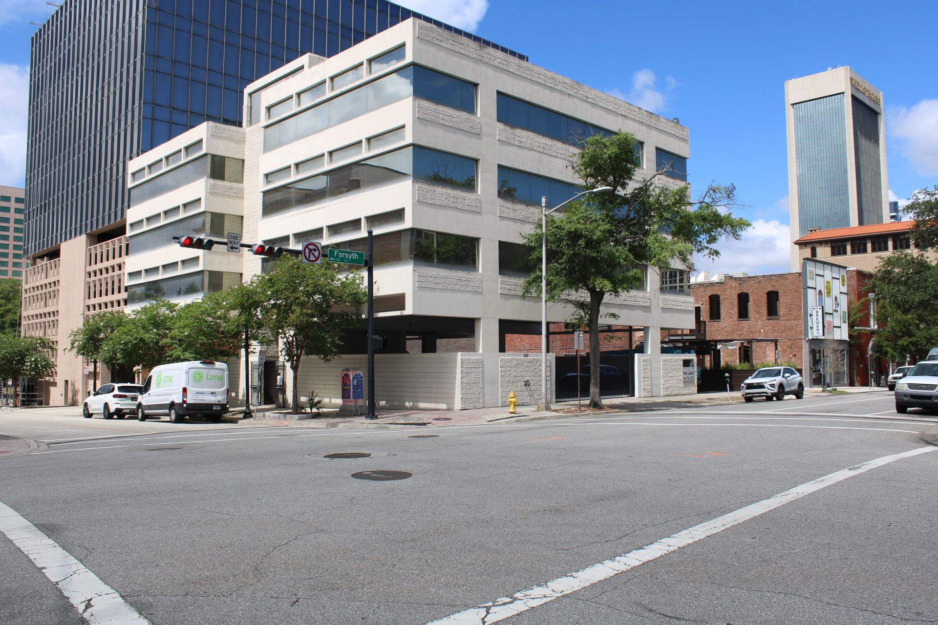 A busy intersection with a large building in the background