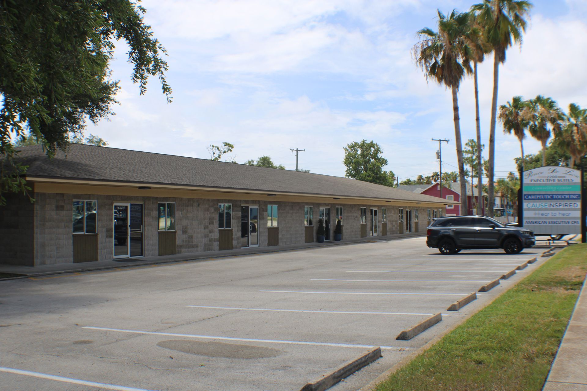 A car is parked in a parking lot in front of a building