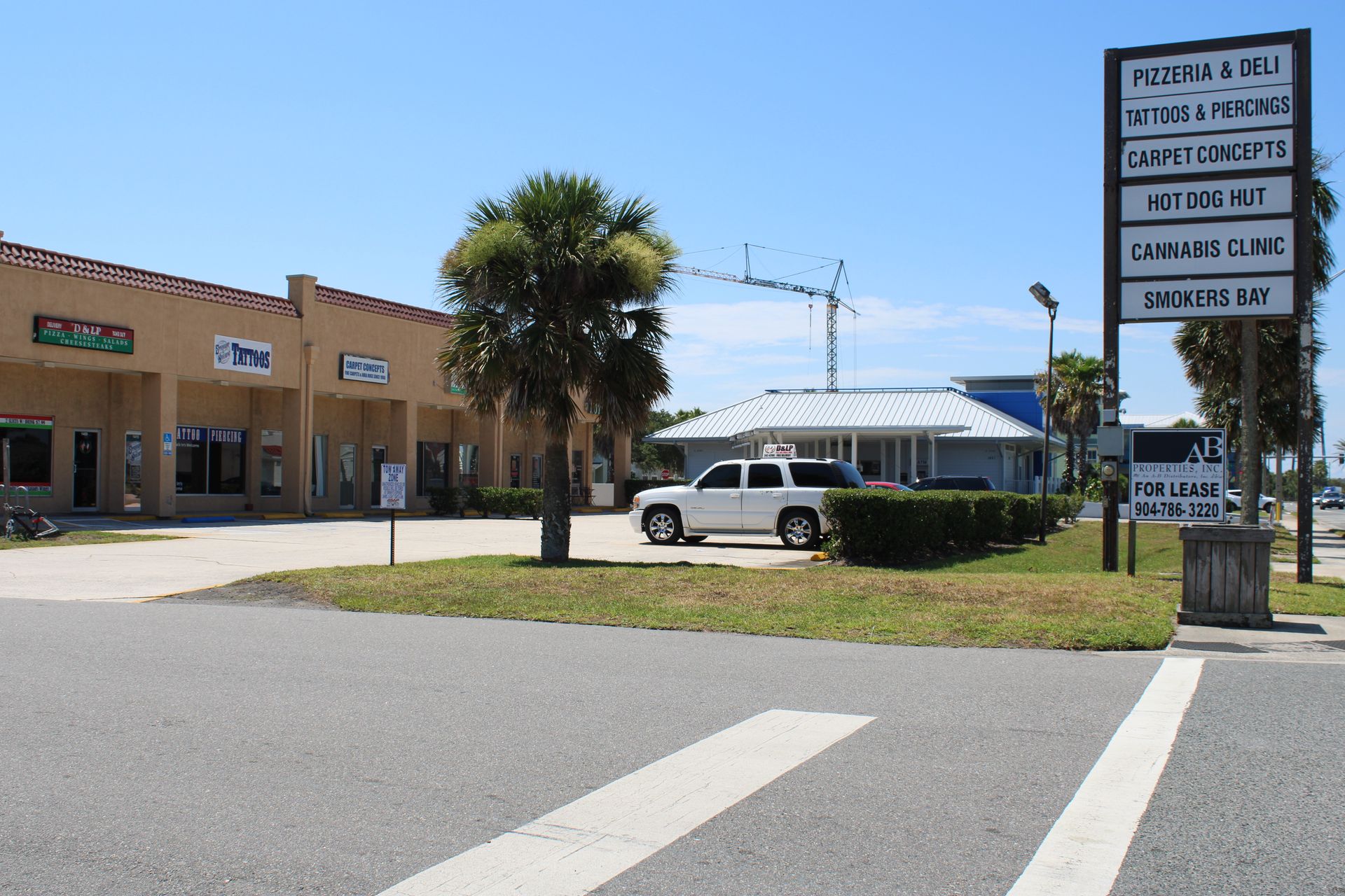 A white suv is parked in front of a building.