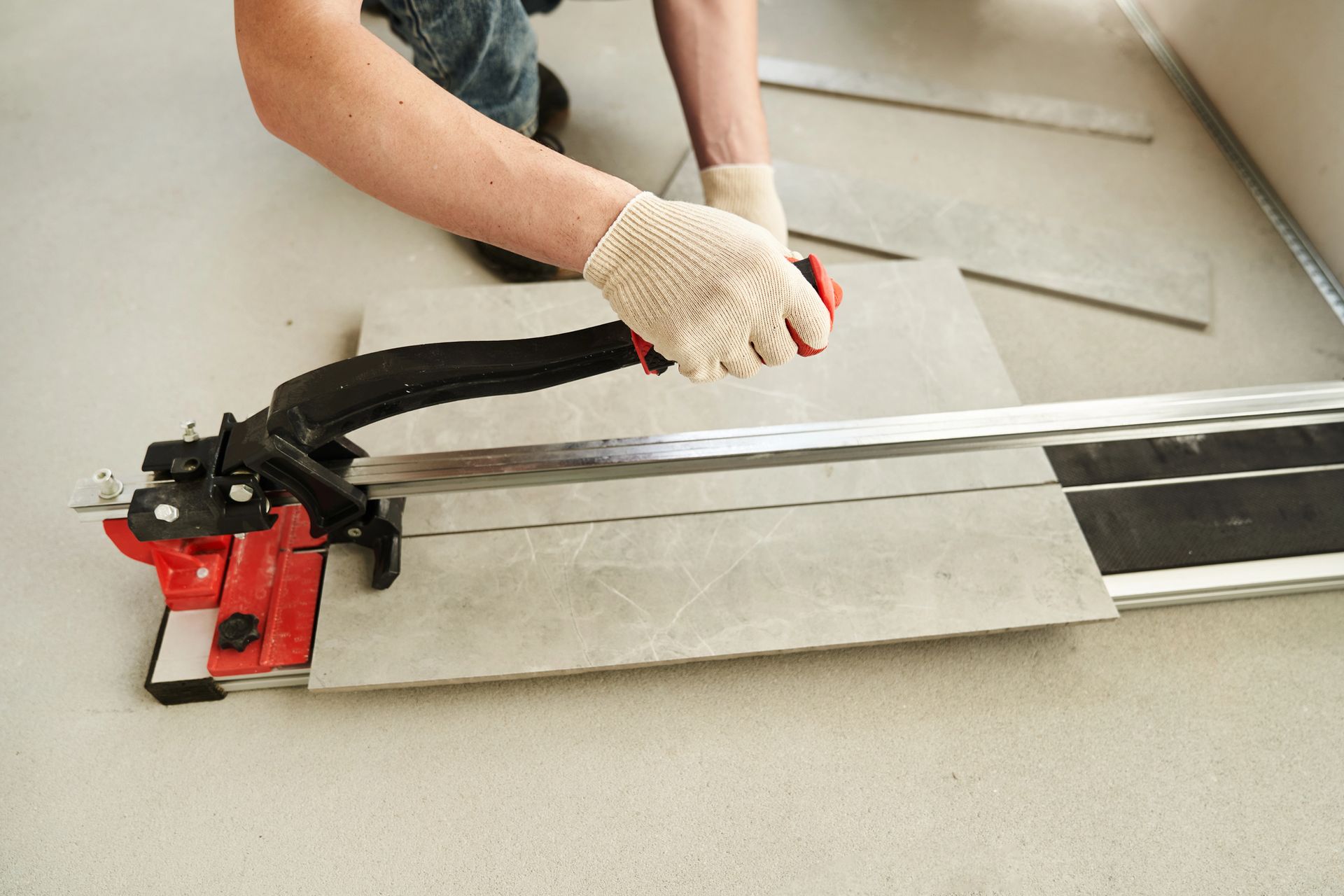 Due persone esaminano i progetti, con strumenti come una livella e un pennello sul tavolo.