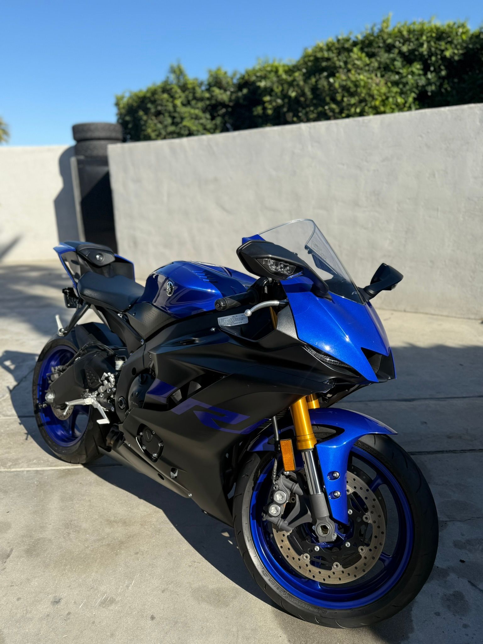 Man in black shirt sanding a car door in a garage.