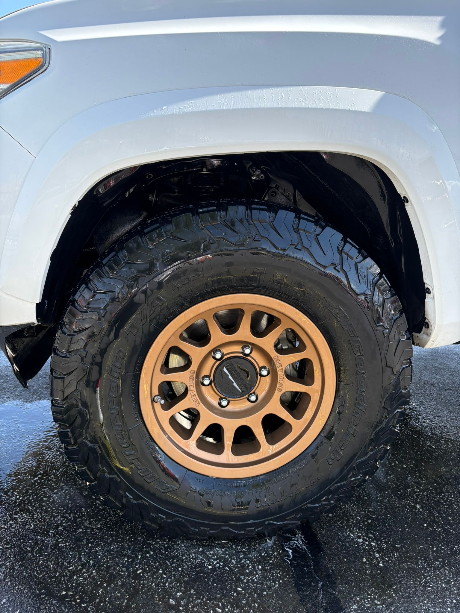 Gloved hand cleaning a car steering wheel with a brush.