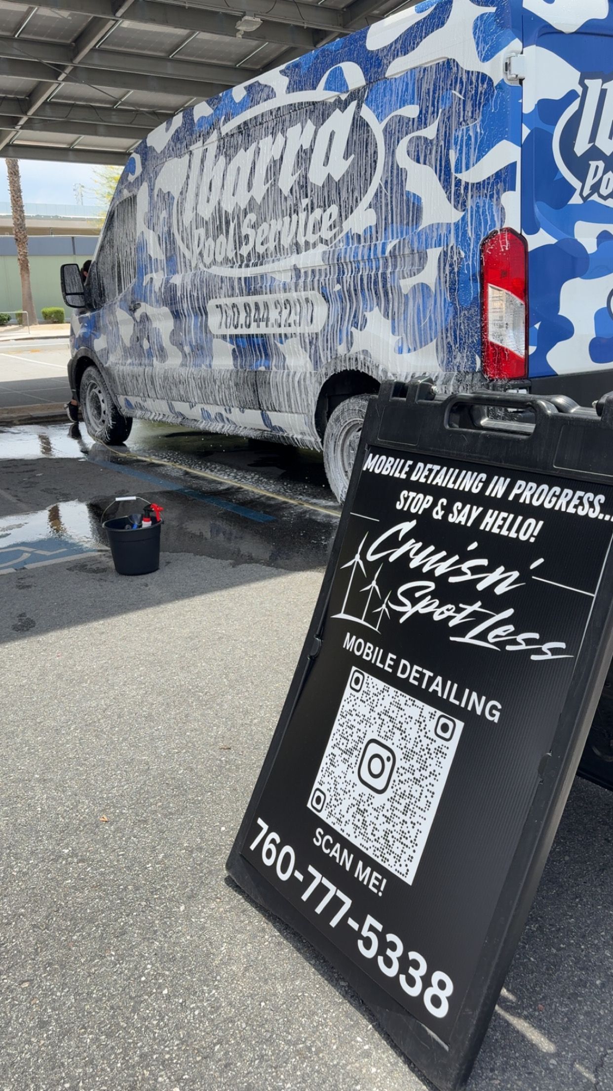Person in blue gloves polishing a black car with a yellow and black buffer.