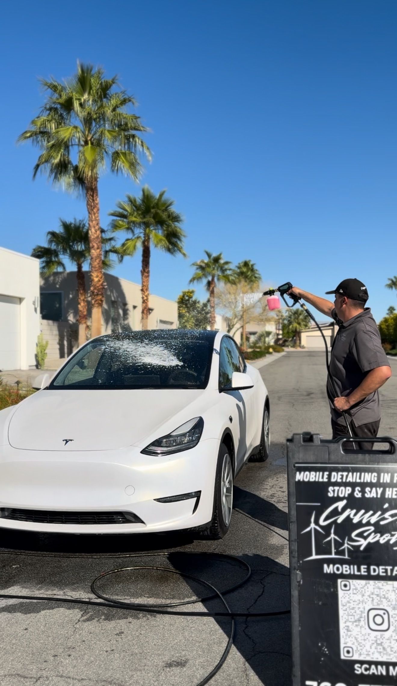 Man cleaning the interior of a car, wiping the seat with a yellow cloth.
