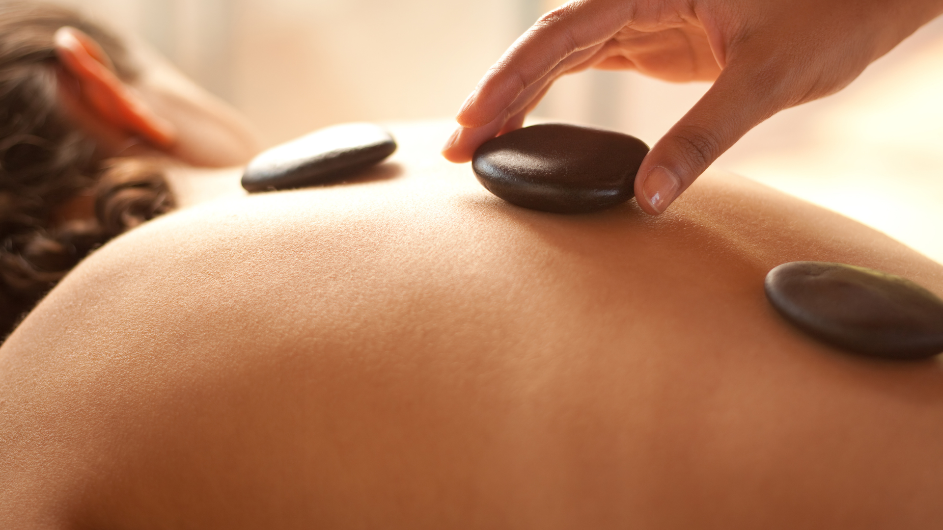 A woman 's feet with pink nails and a pink flower.