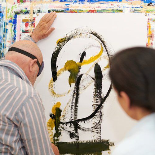 Mann malt ein Bild in Gelb und Schwarz