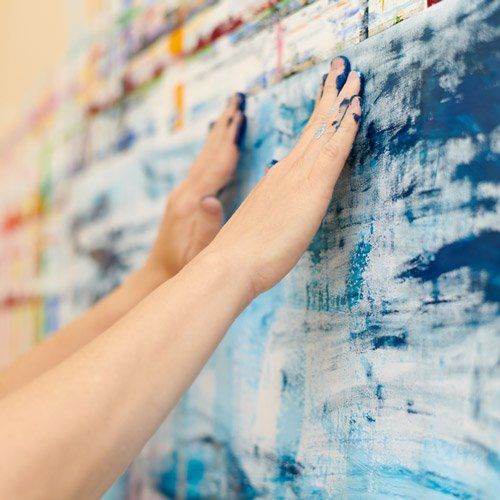 Frau malt mit ihren Händen ein Bild