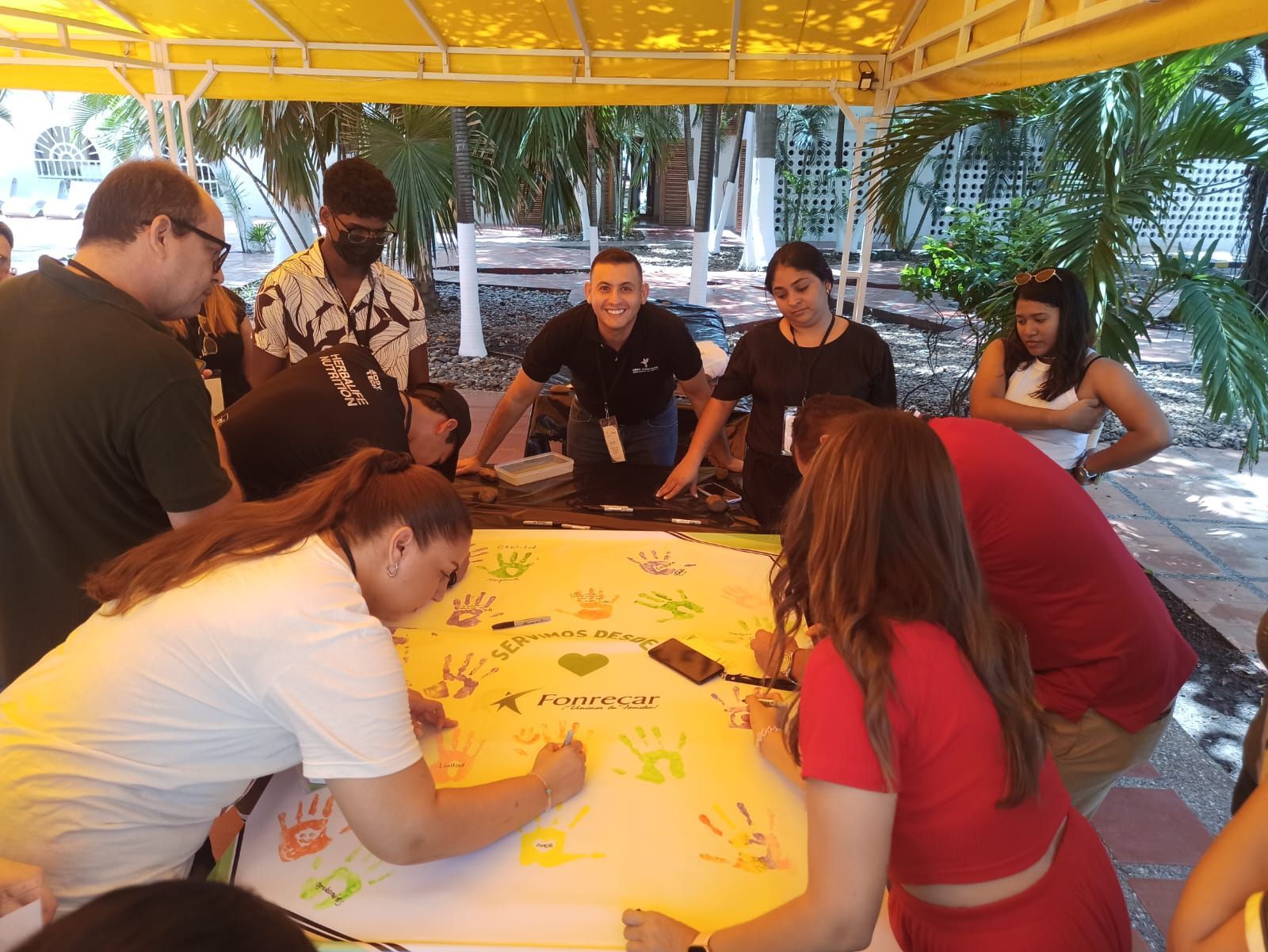 Un grupo de personas está sentado alrededor de una mesa escribiendo en un trozo de papel.