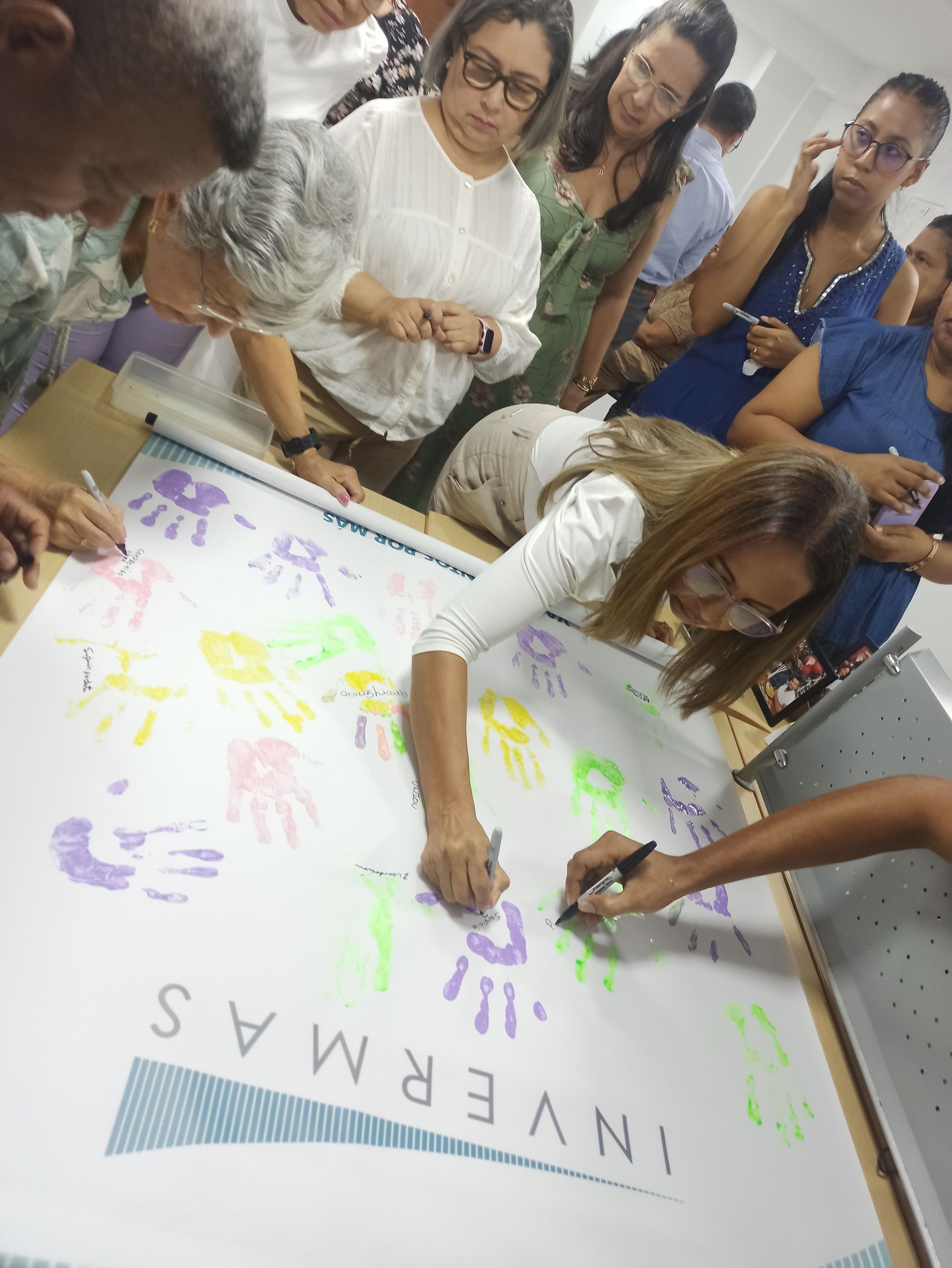 Un grupo de personas está firmando un cartel que dice invernas