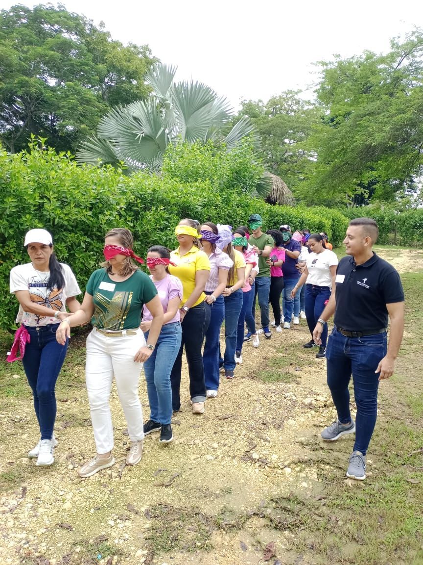 Un grupo de personas con los ojos vendados camina por un sendero de tierra.