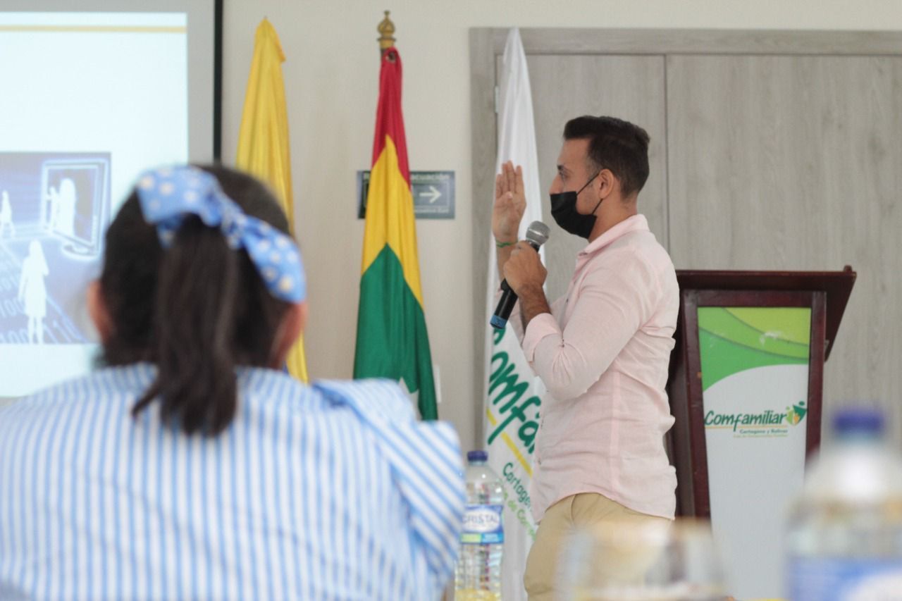 Un hombre que lleva una máscara está dando una presentación a un grupo de personas.