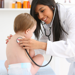 pediatrician using stethoscope on baby