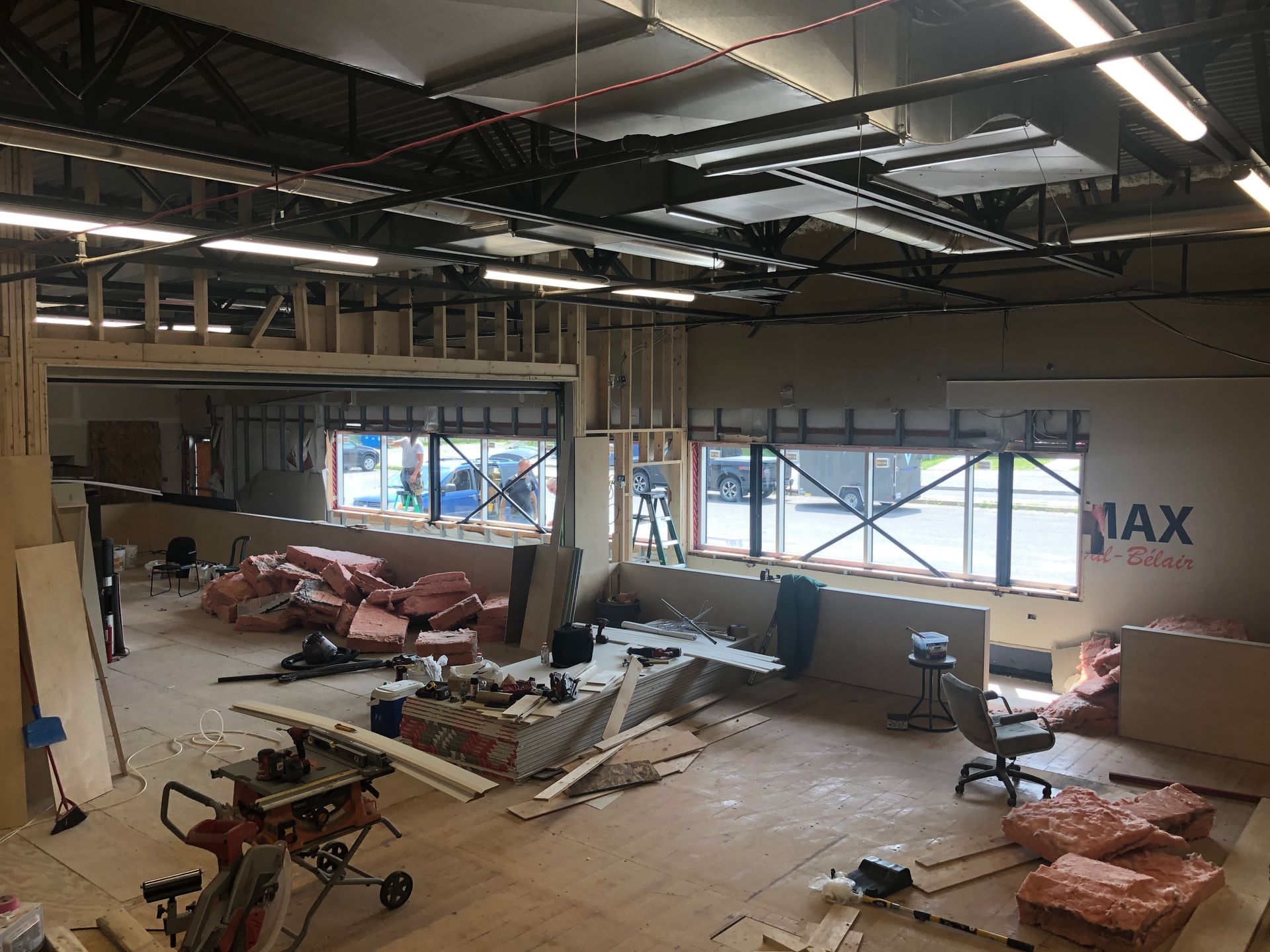 Une grande pièce avec une table et des chaises est en cours de rénovation.