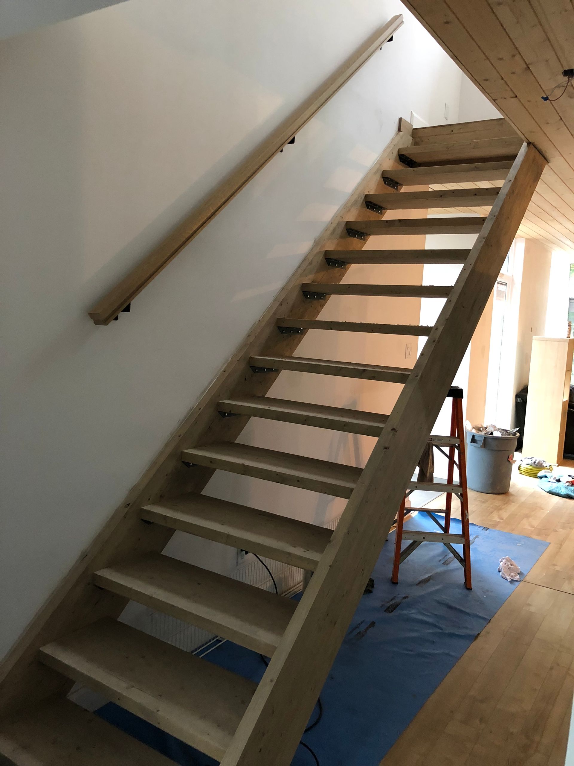 Un escalier en bois est en cours de construction dans une maison