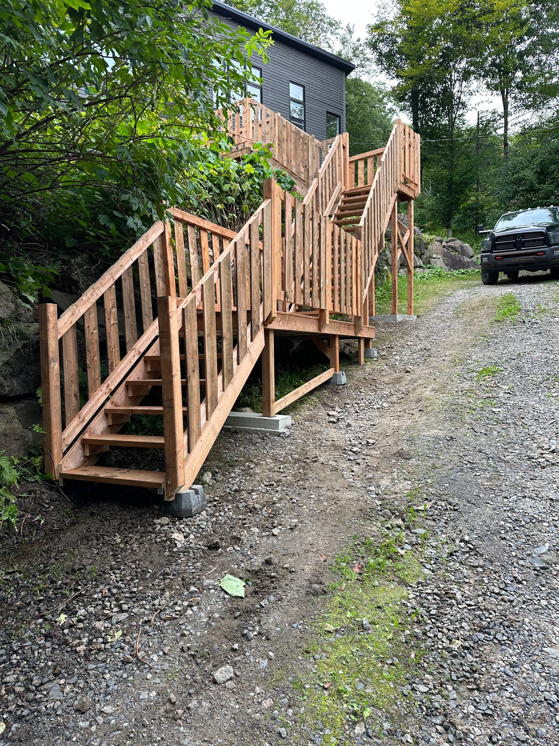 Une terrasse en bois avec des escaliers menant à une maison.