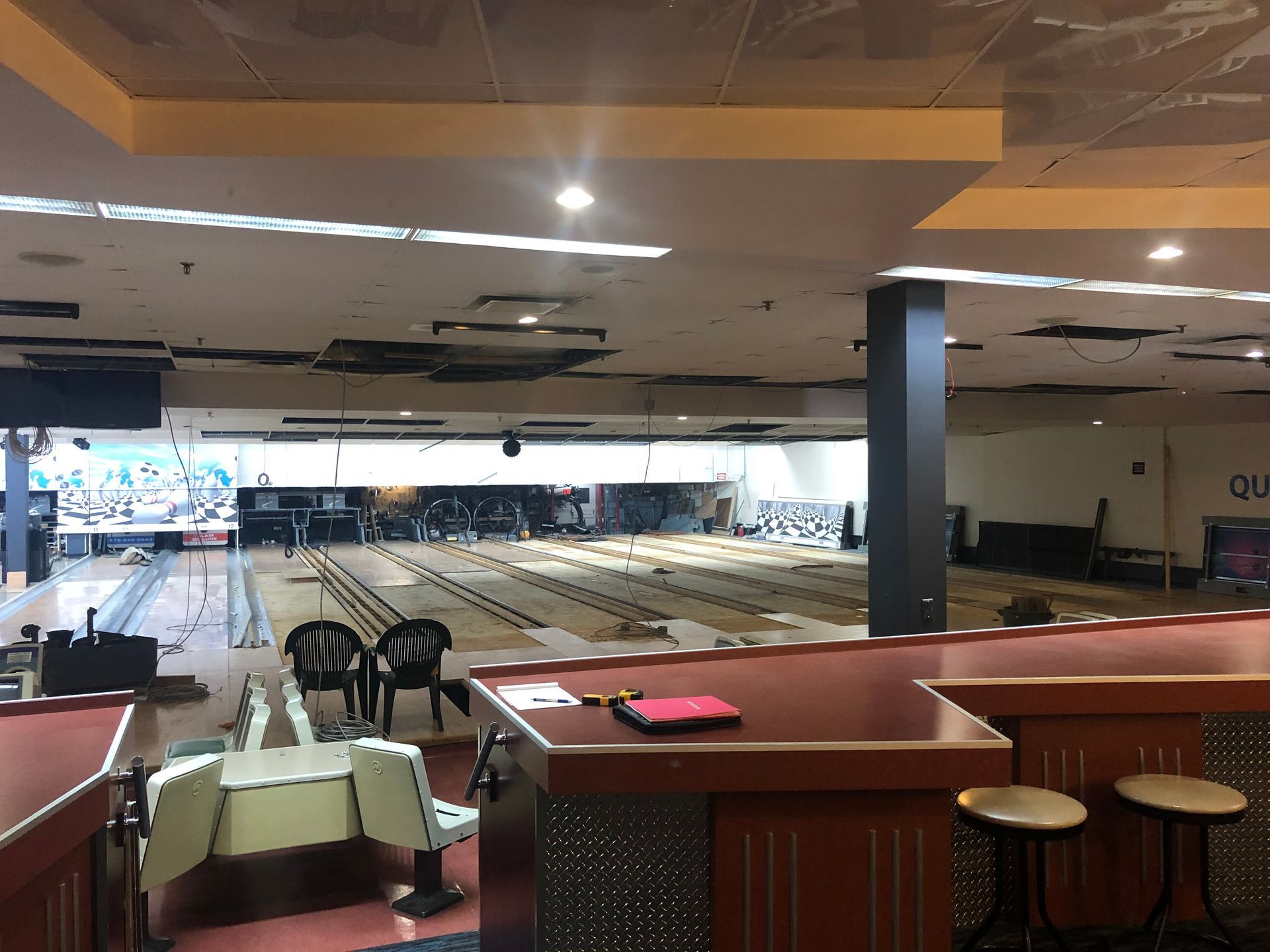 Une piste de bowling vide avec un bar et des tabourets