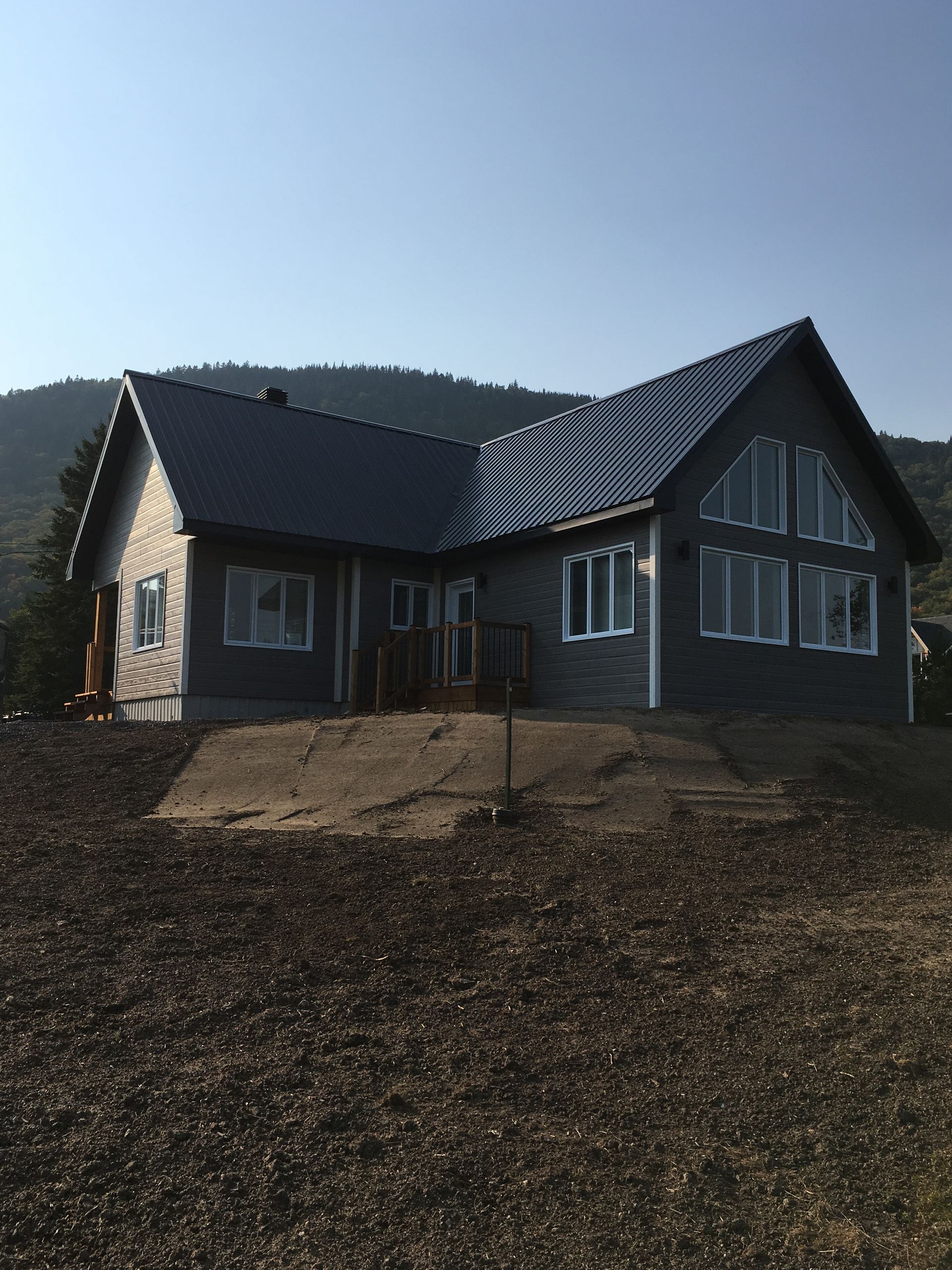 Une maison avec un toit en métal et beaucoup de fenêtres