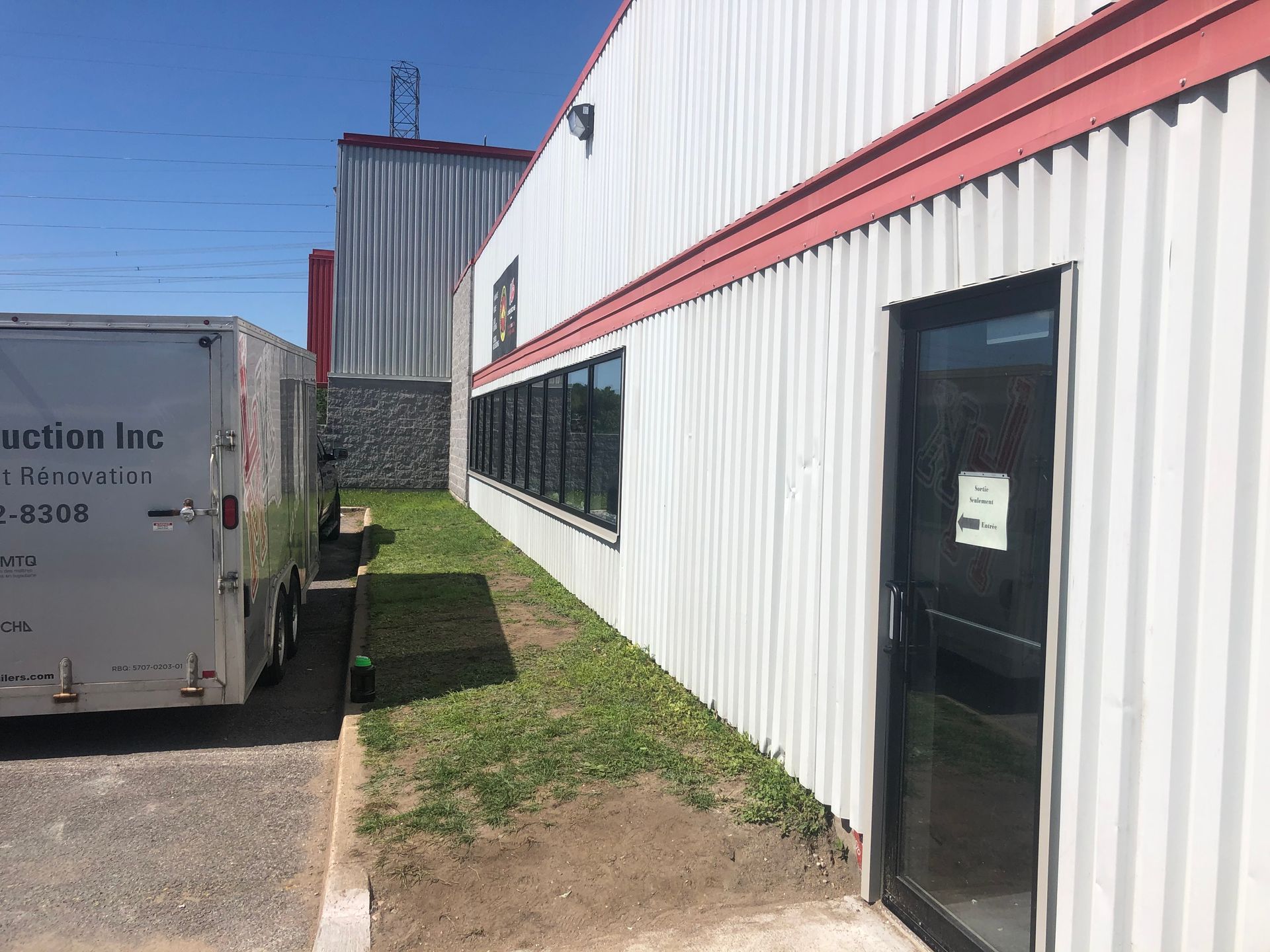 Un camion blanc est garé devant un immeuble.